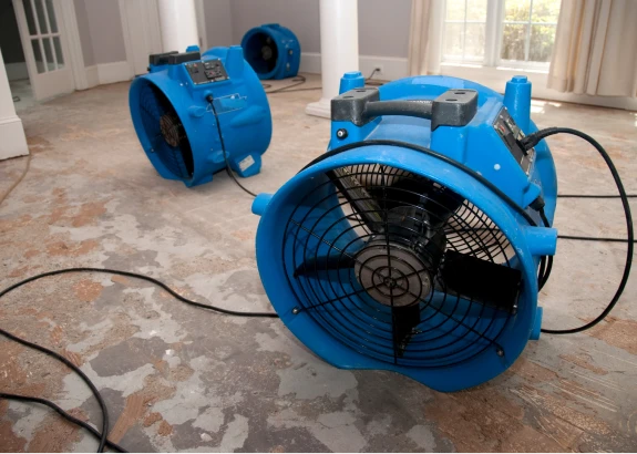 Blue industrial fans drying hardwood floor